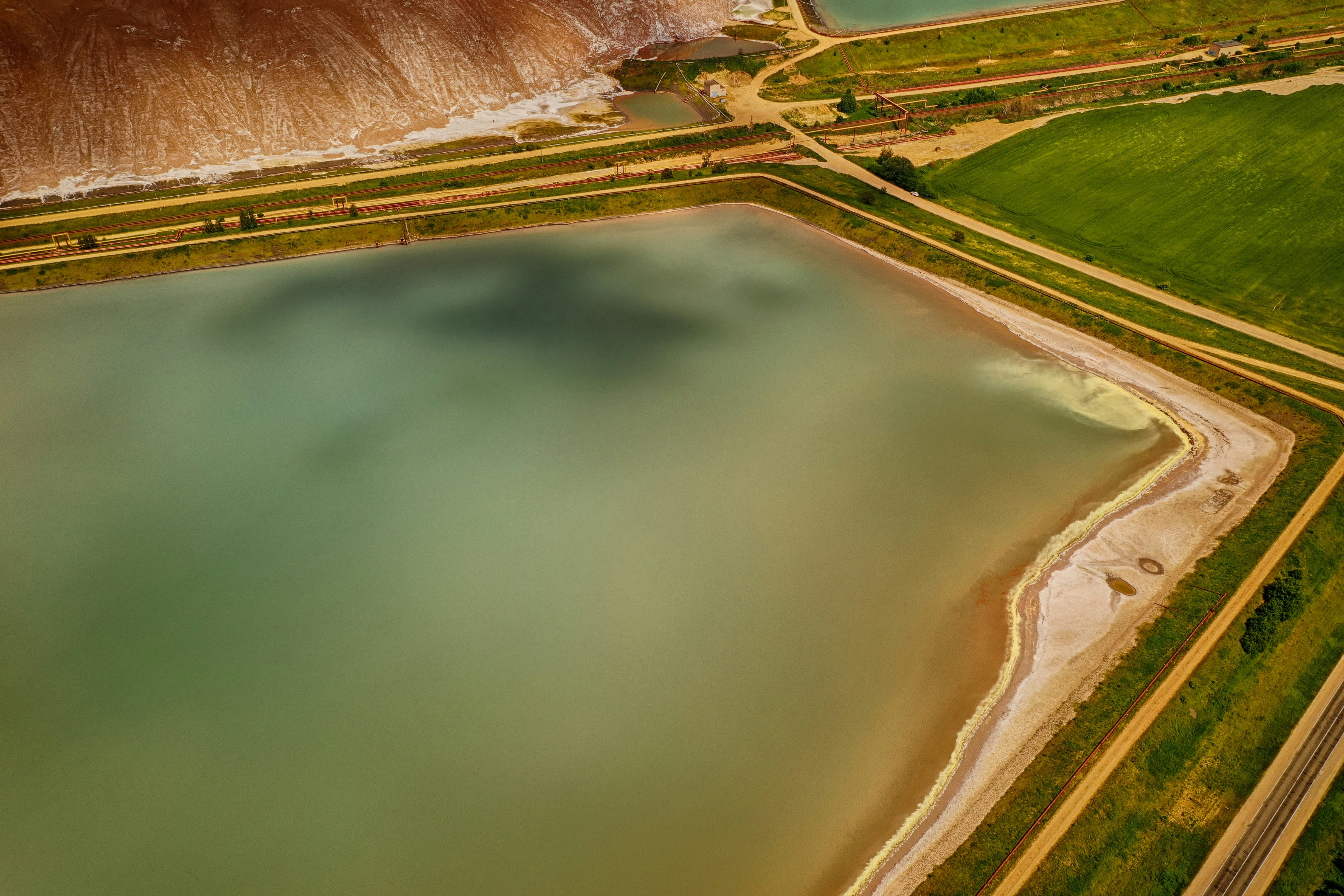 aerial view of lake and green grass field